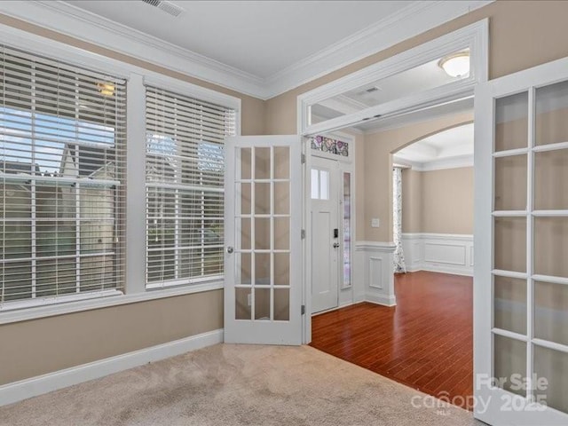 spare room with ornamental molding and carpet