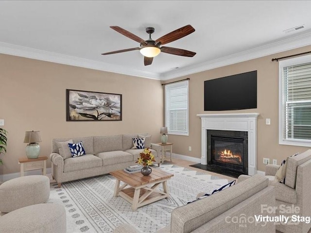 living room with ornamental molding and ceiling fan