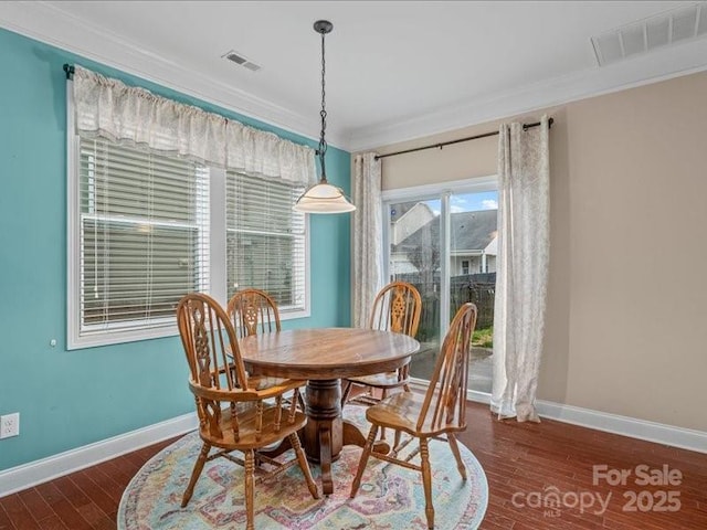 dining space featuring ornamental molding and dark hardwood / wood-style flooring