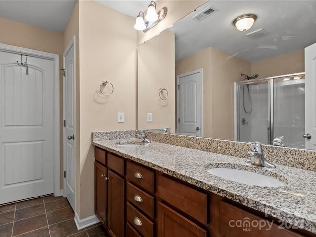 bathroom with tile patterned floors, vanity, and a shower with shower door