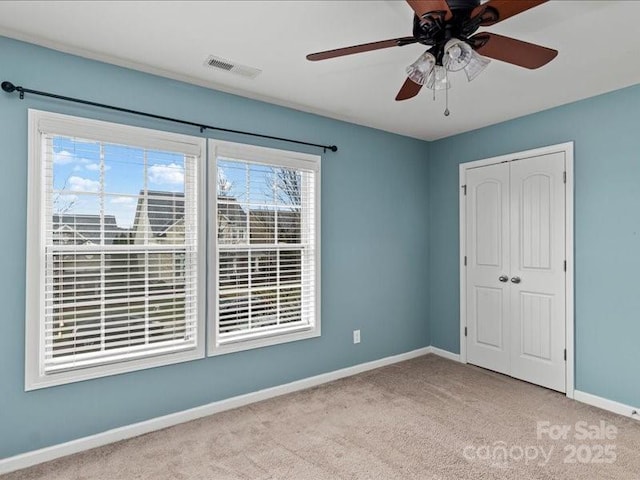 unfurnished bedroom featuring light carpet, ceiling fan, and a closet