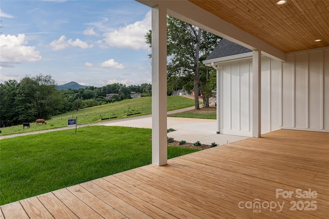 wooden deck featuring a yard, a patio area, and a mountain view