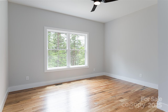 empty room with baseboards, visible vents, light wood finished floors, and ceiling fan
