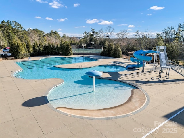 view of pool featuring a water slide and a patio area