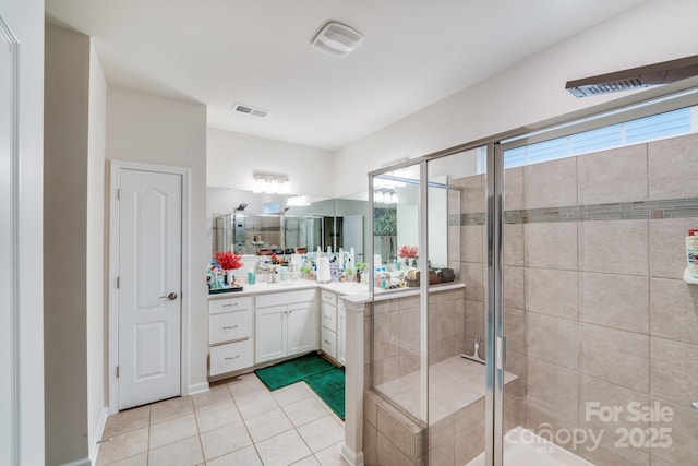 bathroom featuring vanity, a shower with shower door, and tile patterned flooring