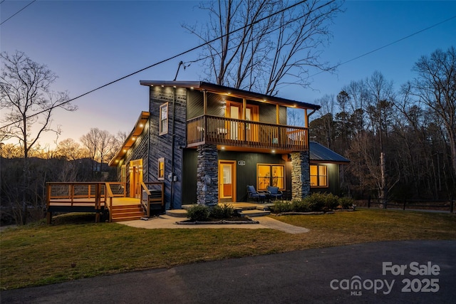 contemporary house featuring a wooden deck, a lawn, and a balcony