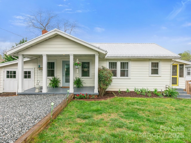 single story home featuring metal roof, a chimney, a front lawn, and a porch