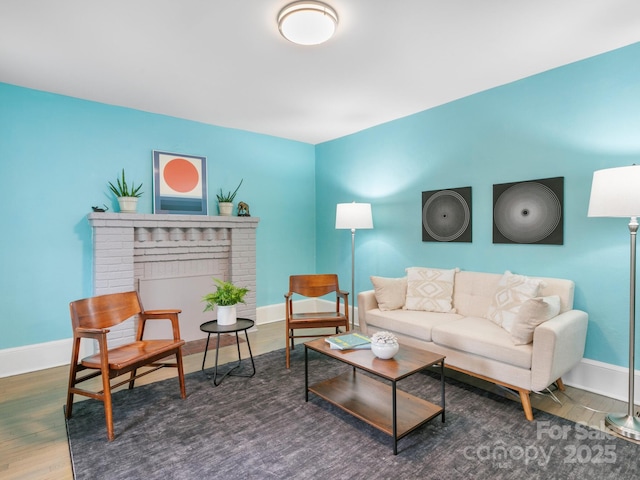 living room featuring baseboards, a fireplace, and wood finished floors