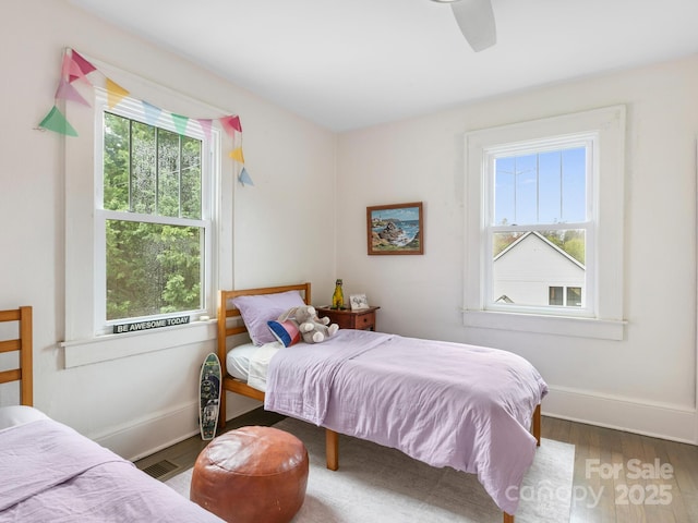 bedroom with visible vents, baseboards, and wood finished floors