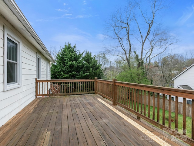 wooden terrace featuring a lawn and fence