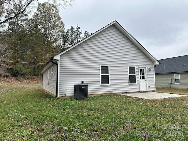 back of house with a lawn, cooling unit, and a patio area