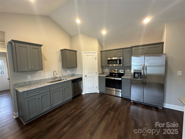 kitchen featuring sink, gray cabinetry, stainless steel appliances, dark hardwood / wood-style flooring, and vaulted ceiling