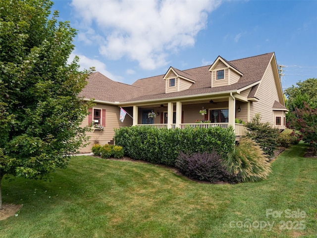 cape cod-style house with a front yard, ceiling fan, and covered porch