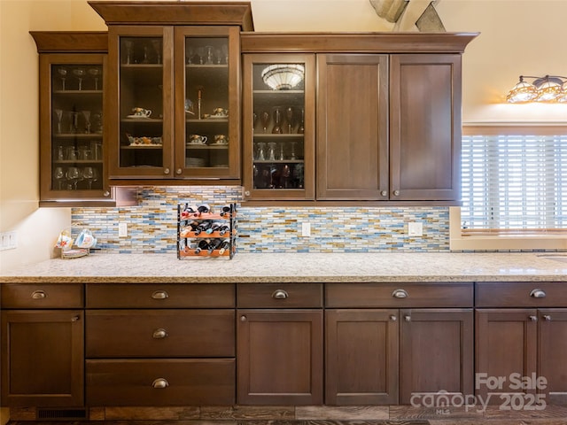 bar featuring light stone counters and decorative backsplash