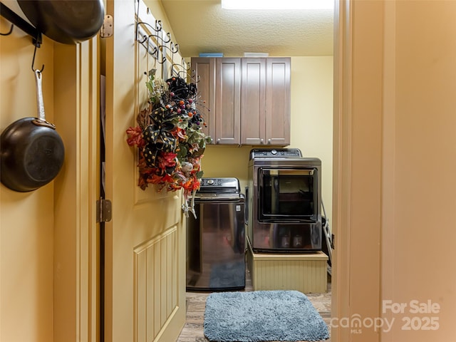 washroom featuring cabinets, independent washer and dryer, and a textured ceiling