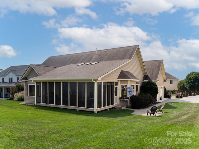 rear view of property with a lawn, a sunroom, and a patio