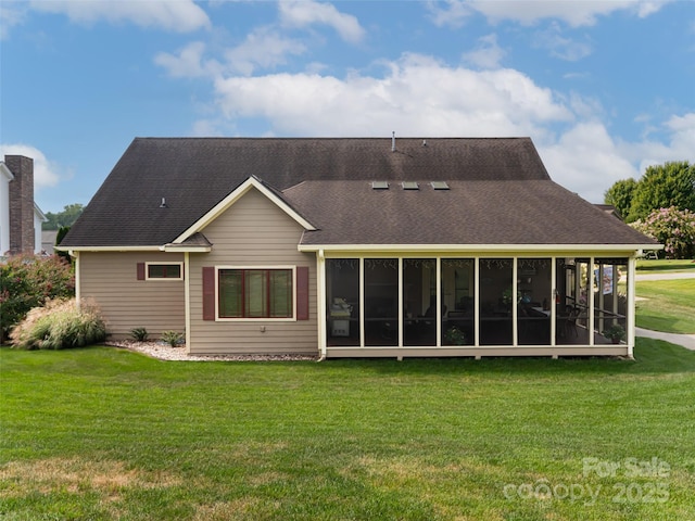 rear view of property featuring a sunroom and a lawn