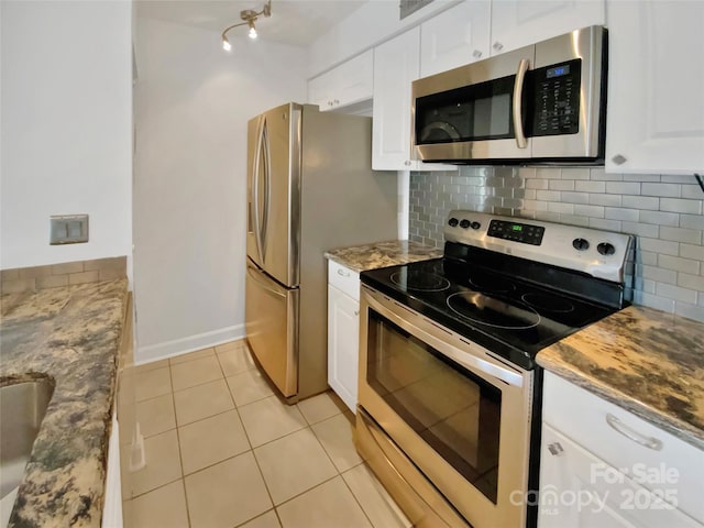 kitchen with tasteful backsplash, appliances with stainless steel finishes, and white cabinets