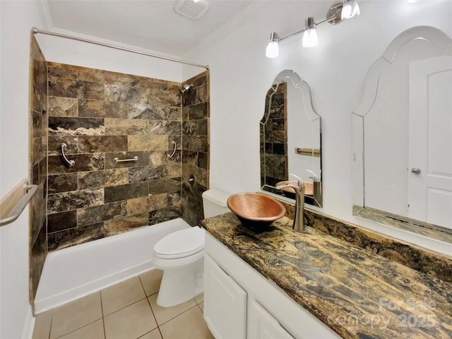 bathroom with tile patterned flooring, vanity, tiled shower, and toilet