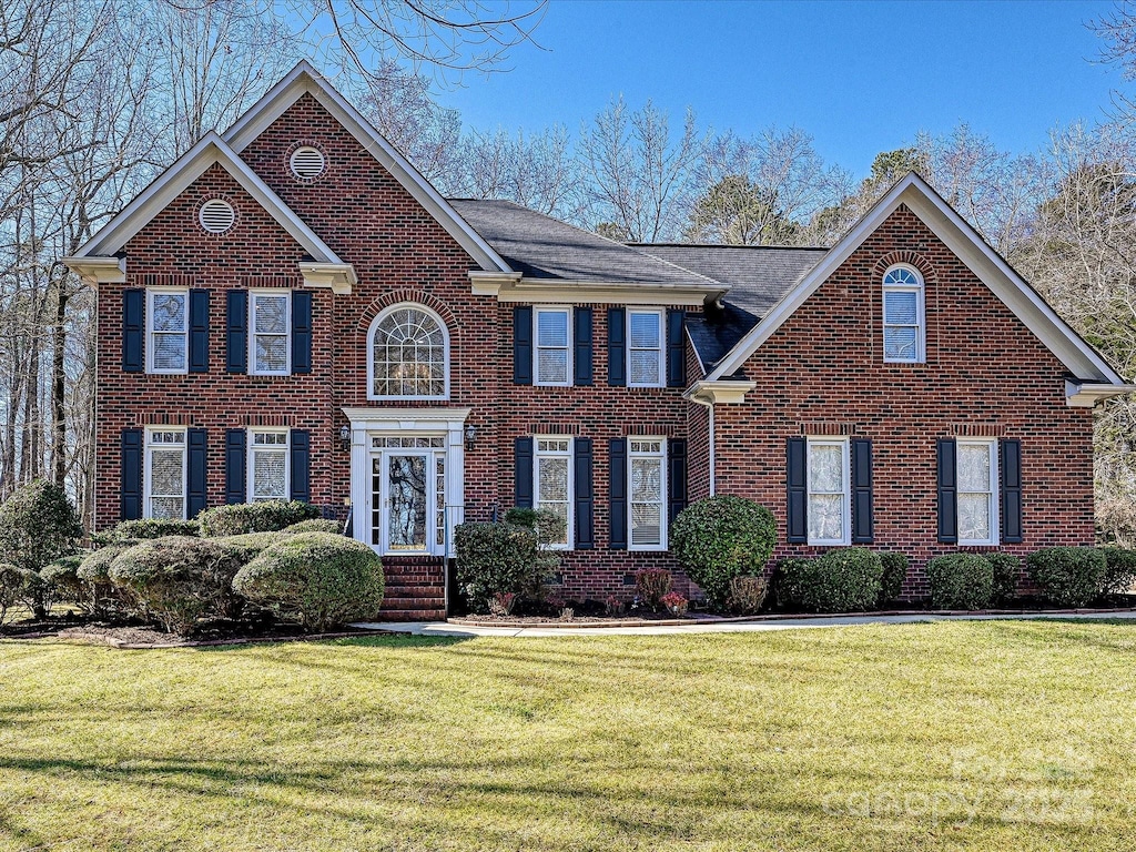 colonial inspired home featuring a front yard