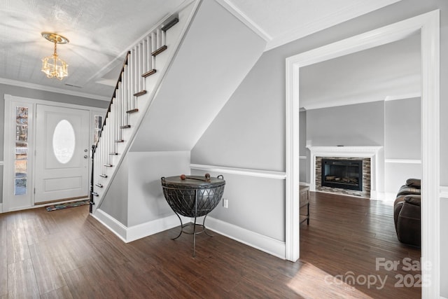 entryway with ornamental molding, a notable chandelier, and dark hardwood / wood-style flooring