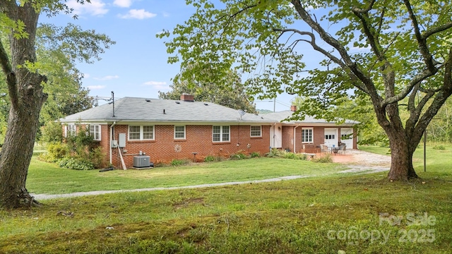 rear view of property featuring a yard, a patio area, and central air condition unit