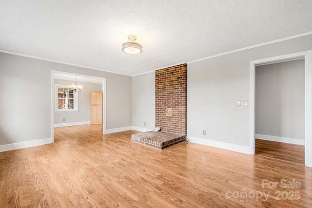 unfurnished living room featuring ornamental molding, a chandelier, a textured ceiling, and light wood-type flooring