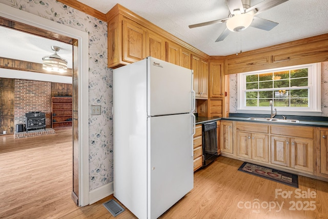 kitchen featuring dishwasher, white fridge, sink, and a textured ceiling