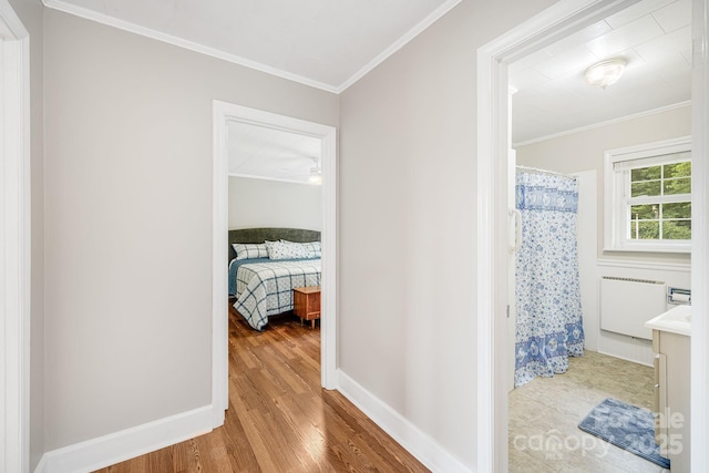 hall featuring crown molding, radiator, and light hardwood / wood-style flooring