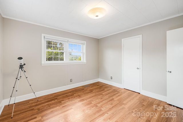 spare room with crown molding and light hardwood / wood-style floors