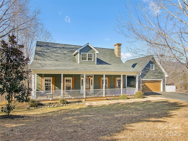 cape cod-style house featuring a porch, a garage, and a front lawn