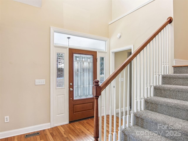 foyer featuring hardwood / wood-style flooring and a high ceiling