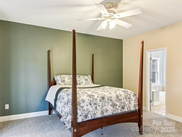 bedroom with ceiling fan, light carpet, and ensuite bath