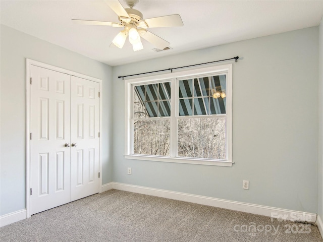 unfurnished bedroom with a closet, ceiling fan, and carpet flooring