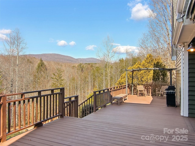 wooden deck with a mountain view and grilling area