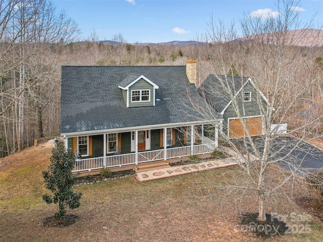 view of front of house with a porch, a garage, and a front yard