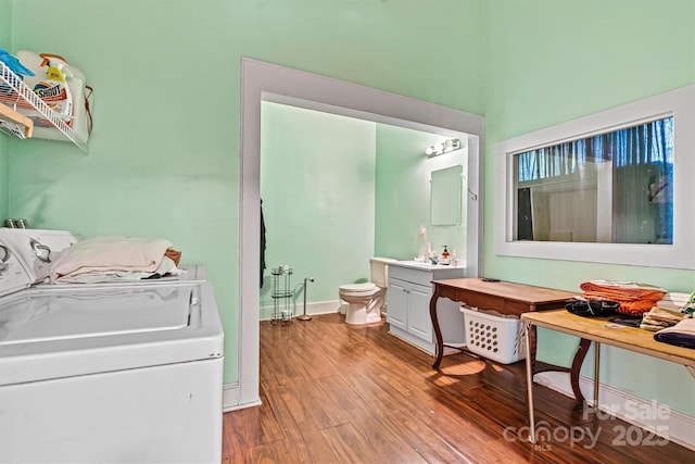 bathroom with wood-type flooring, toilet, vanity, and washing machine and dryer