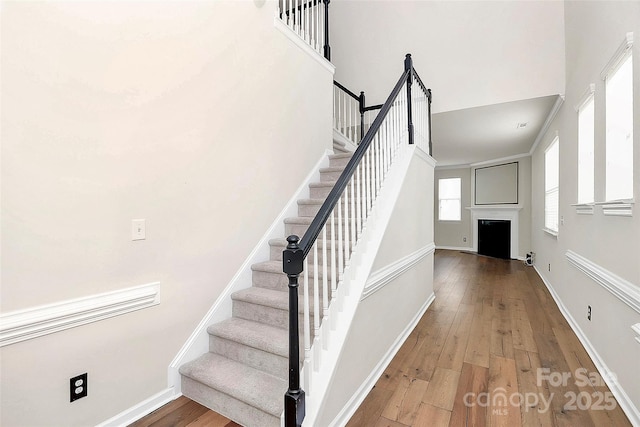 stairway featuring hardwood / wood-style floors and a high ceiling