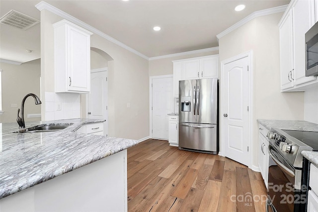 kitchen with light stone counters, sink, stainless steel appliances, and white cabinets