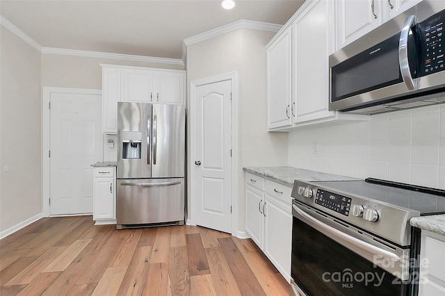 kitchen with white cabinetry, light stone counters, crown molding, and appliances with stainless steel finishes