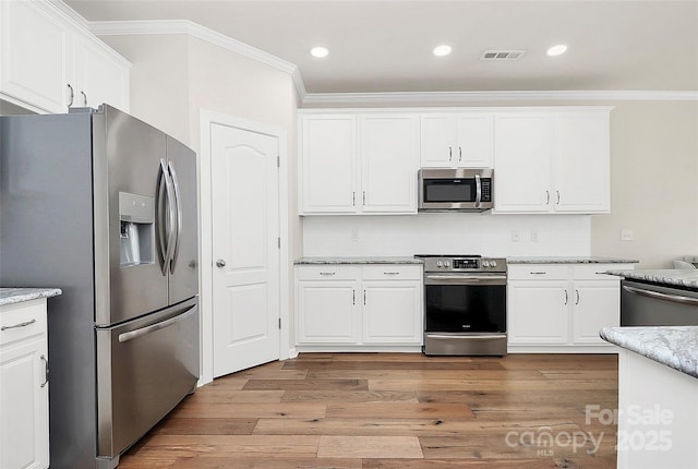 kitchen with crown molding, appliances with stainless steel finishes, and white cabinets