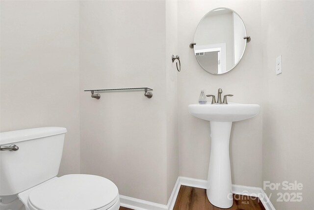 bathroom with hardwood / wood-style flooring and toilet