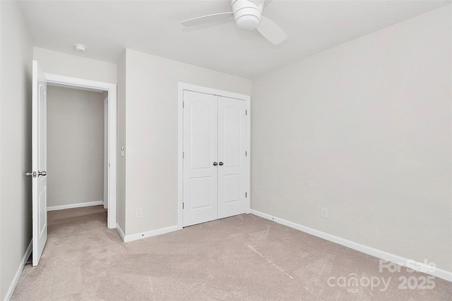 unfurnished bedroom featuring ceiling fan, light colored carpet, and a closet