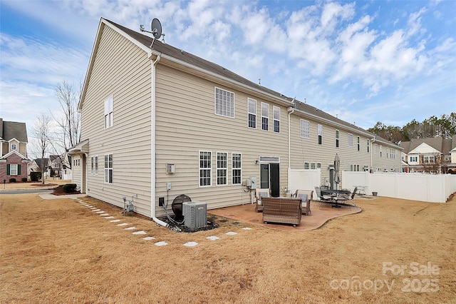 back of property with a yard, central air condition unit, and a patio area