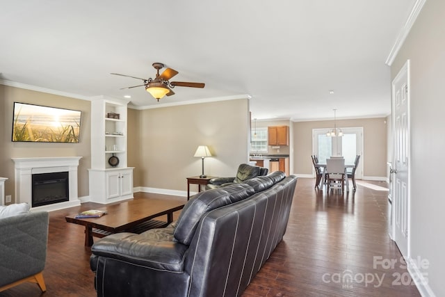 living room with ceiling fan with notable chandelier, ornamental molding, and dark hardwood / wood-style floors