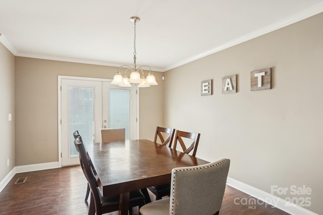 dining space featuring crown molding, dark hardwood / wood-style flooring, a chandelier, and french doors