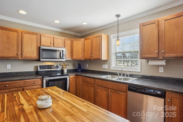 kitchen with wood counters, decorative light fixtures, sink, stainless steel appliances, and crown molding