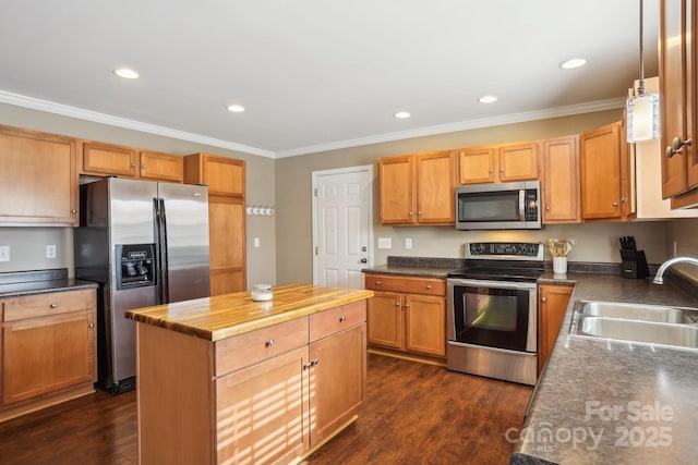 kitchen with appliances with stainless steel finishes, sink, dark hardwood / wood-style floors, and decorative light fixtures