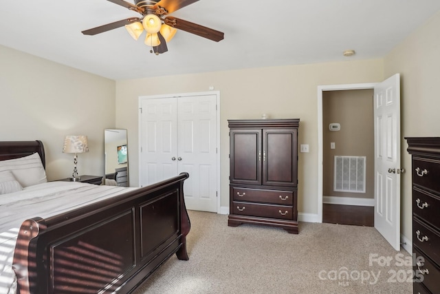 carpeted bedroom featuring a closet and ceiling fan