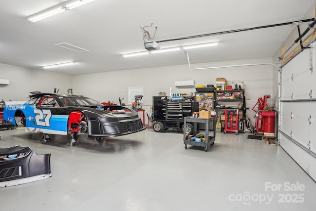 garage featuring a garage door opener and a wall mounted AC